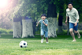 快乐父子在草地上踢足球图片