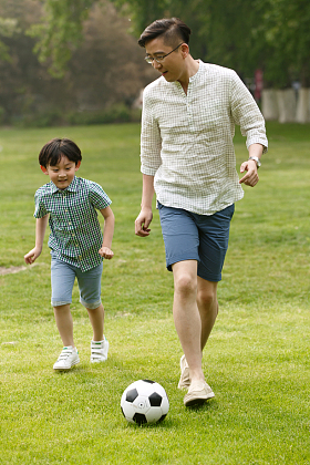 快乐父子在草地上踢足球