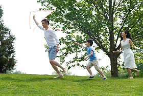 一家三口在草地上放风筝