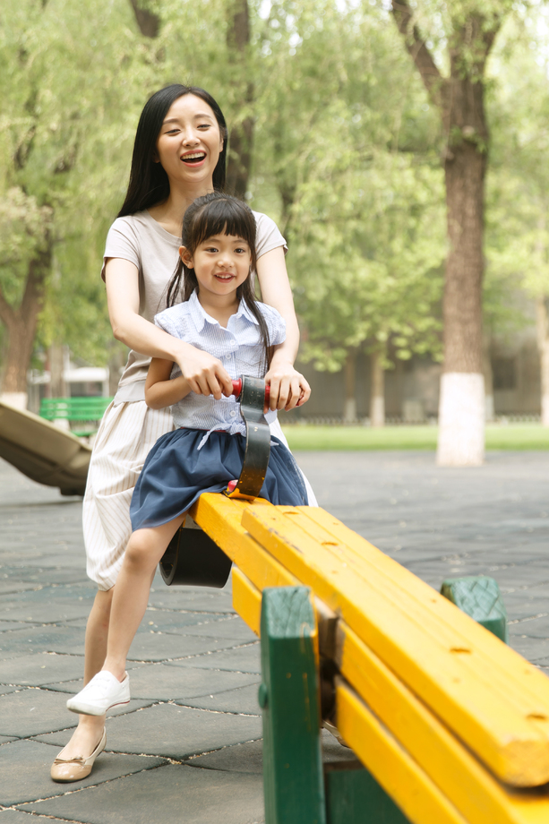 快乐母女玩跷跷板照片