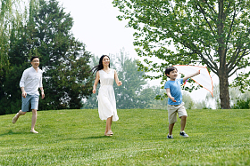 一家三口在草地上放风筝照片