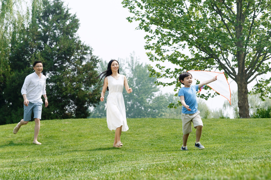 一家三口在草地上放风筝照片