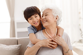 可爱的小男孩和祖母在客厅照片