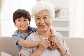 可爱的小男孩和祖母在客厅照片