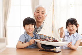 祖父陪孙辈在客厅玩耍图片