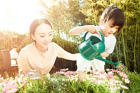 年轻的母亲和女儿在浇花图片