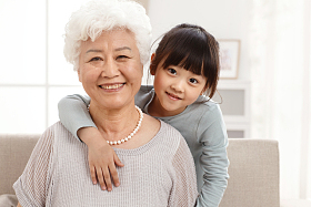 可爱的小女孩和祖母在客厅照片