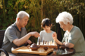 老年夫妇和孙女在院子里下棋图片