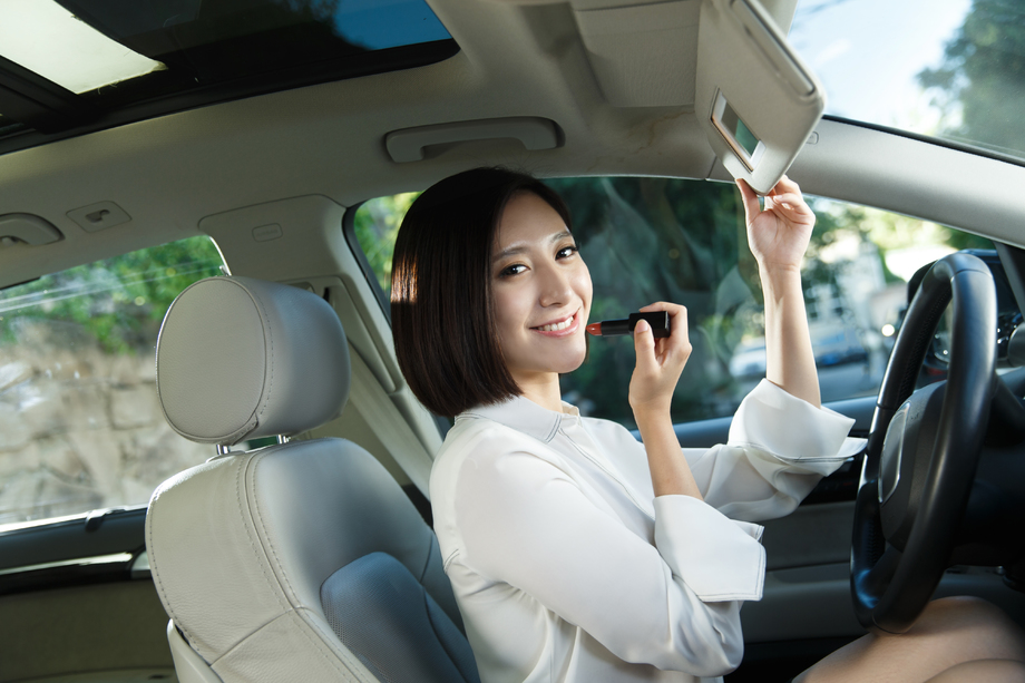 青年女人在汽车里化妆图片