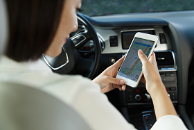 青年女人坐在汽车里看手机