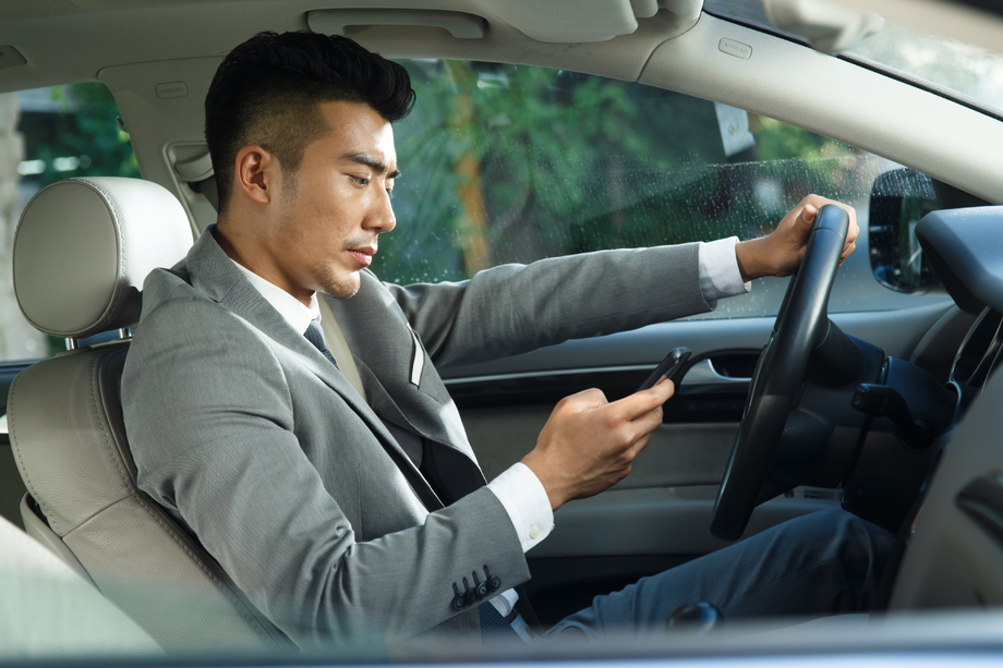 青年男人开车看手机 青年男人开车看手机