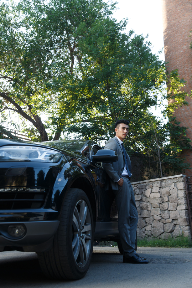 青年男人站在汽车旁边 青年男人站在汽车旁边