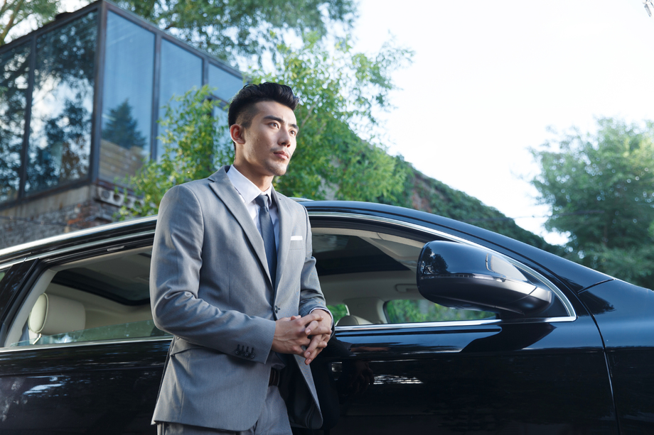 青年男人站在汽车旁边 青年男人站在汽车旁边