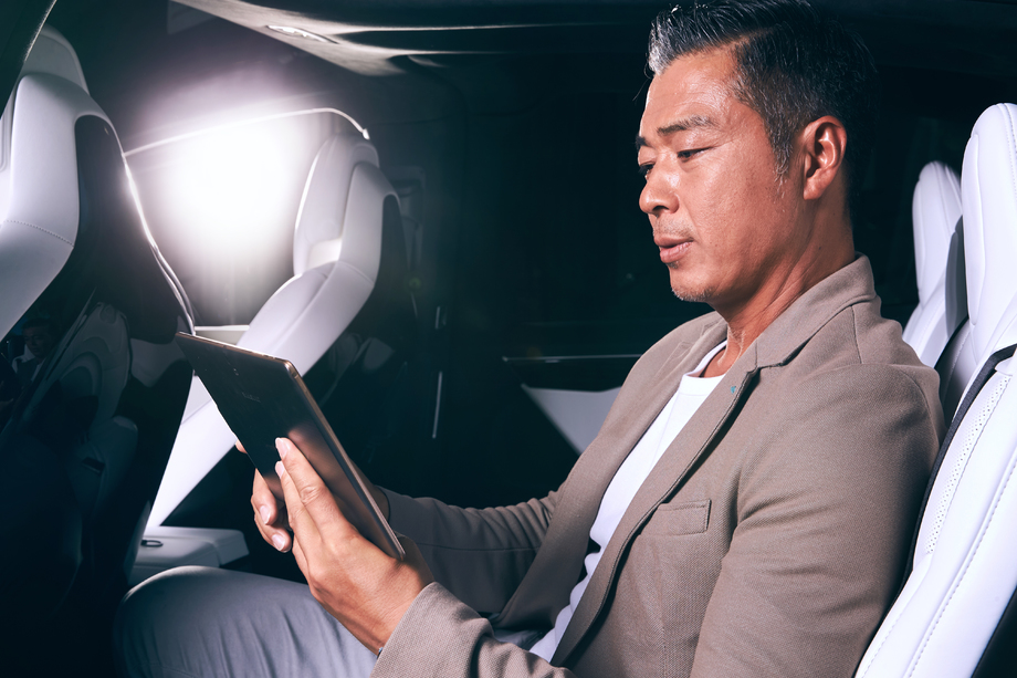 成熟男士坐在汽车里看平板电脑 成熟男士坐在汽车里看平板电脑