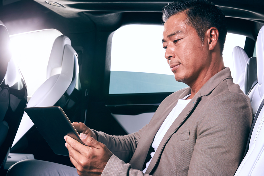 成熟男士坐在汽车里看平板电脑 成熟男士坐在汽车里看平板电脑