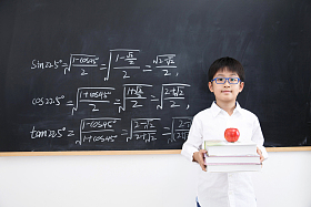 小学男生站在黑板前照片