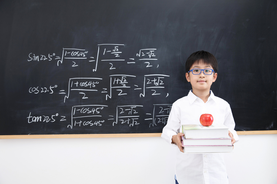 小学男生站在黑板前照片