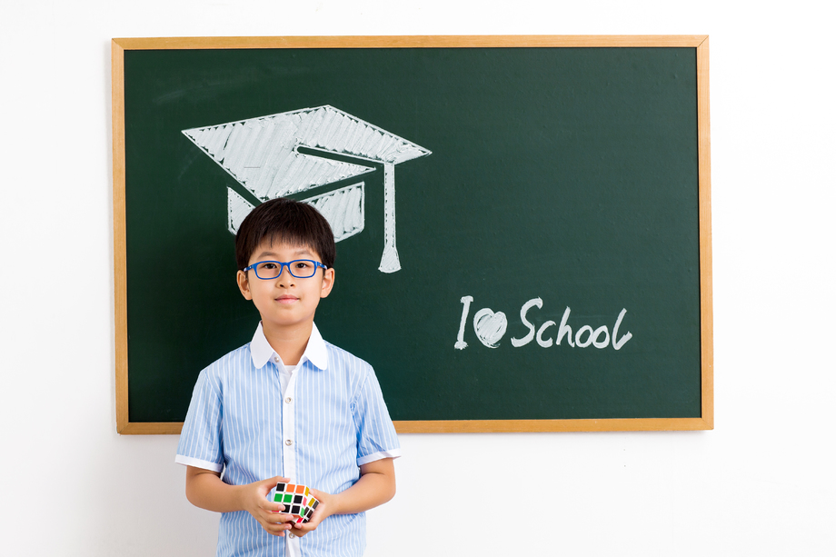 小学男生站在黑板前图片