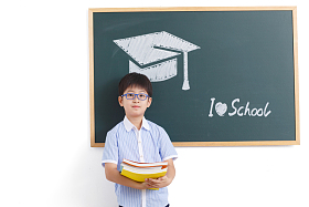 小学男生站在黑板前图片