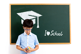 小学男生站在黑板前照片