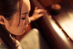 青年女人弹七弦琴照片