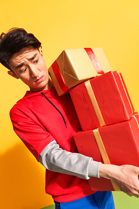 青年男人抱着礼品盒