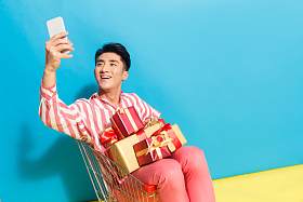 拿着礼品盒的青年男人看手机图片
