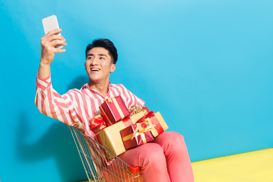 拿着礼品盒的青年男人看手机图片
