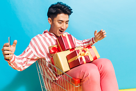 拿着礼品盒的青年男人看手机