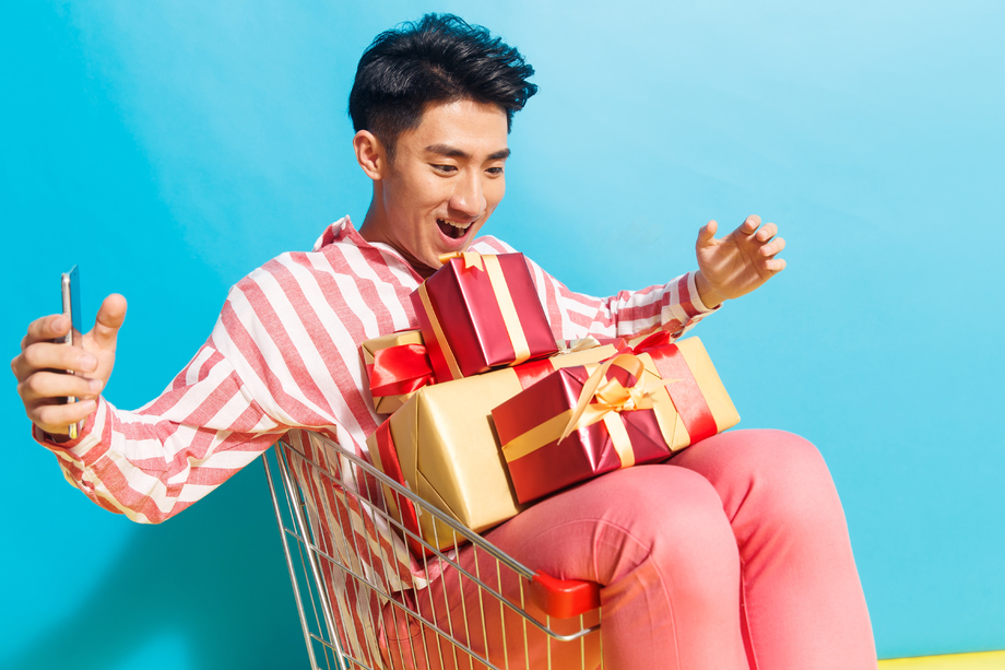 拿着礼品盒的青年男人看手机 拿着礼品盒的青年男人看手机