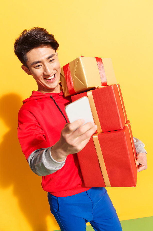 拿着礼品盒的青年男人看手机 拿着礼品盒的青年男人看手机