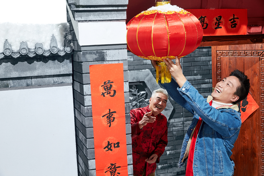 父子过年挂红灯