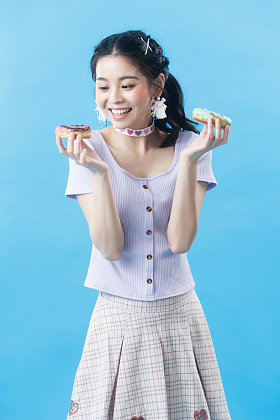 年轻女人吃甜甜圈照片