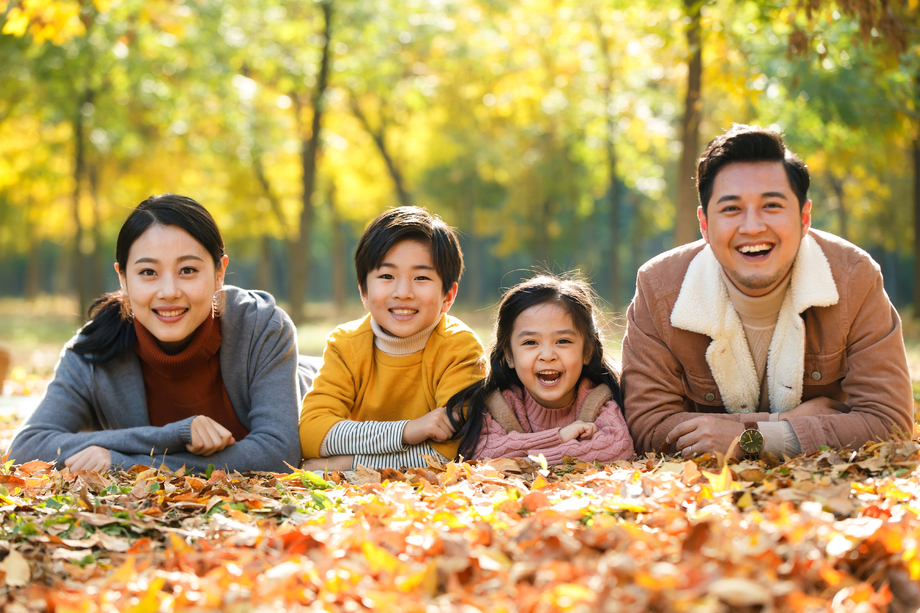 幸福家庭趴在草地上图片