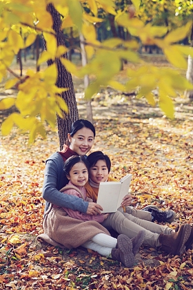 妈妈和孩子在树下看书