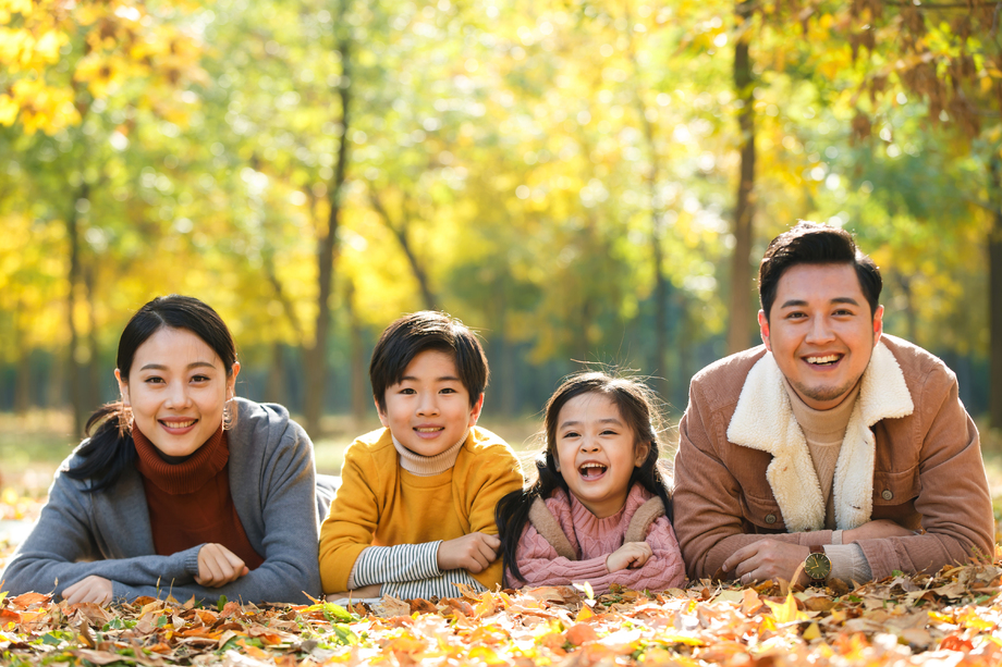 幸福家庭趴在草地上图片