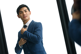 商务青年男人在镜子前穿衣服图片