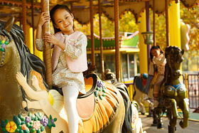 小女孩在玩旋转木马