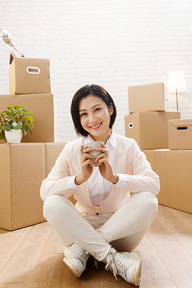 青年女人坐在地板上喝水