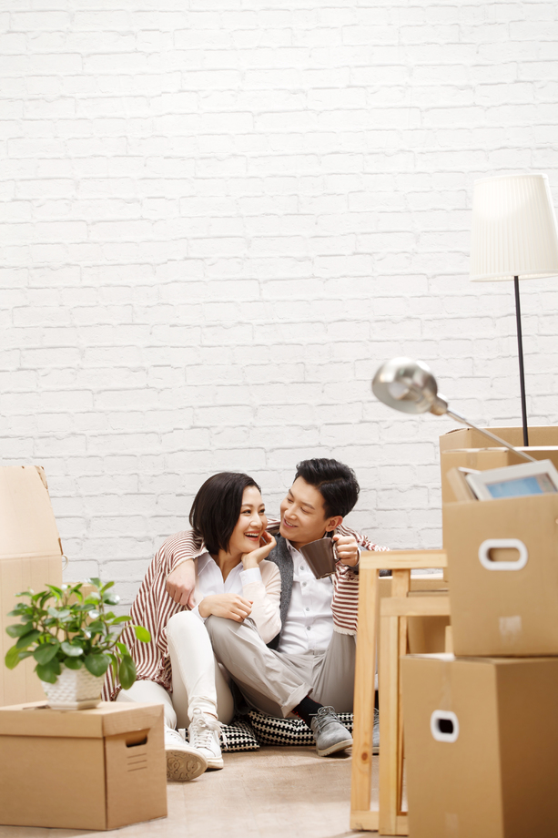 年轻夫妇坐在地板上休息 年轻夫妇坐在地板上休息
