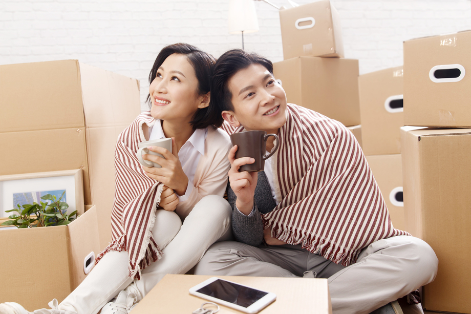 年轻夫妇坐在地板上喝水 年轻夫妇坐在地板上喝水