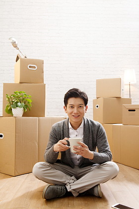 青年男人坐在地板上喝水