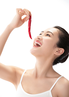 青年女人吃辣椒