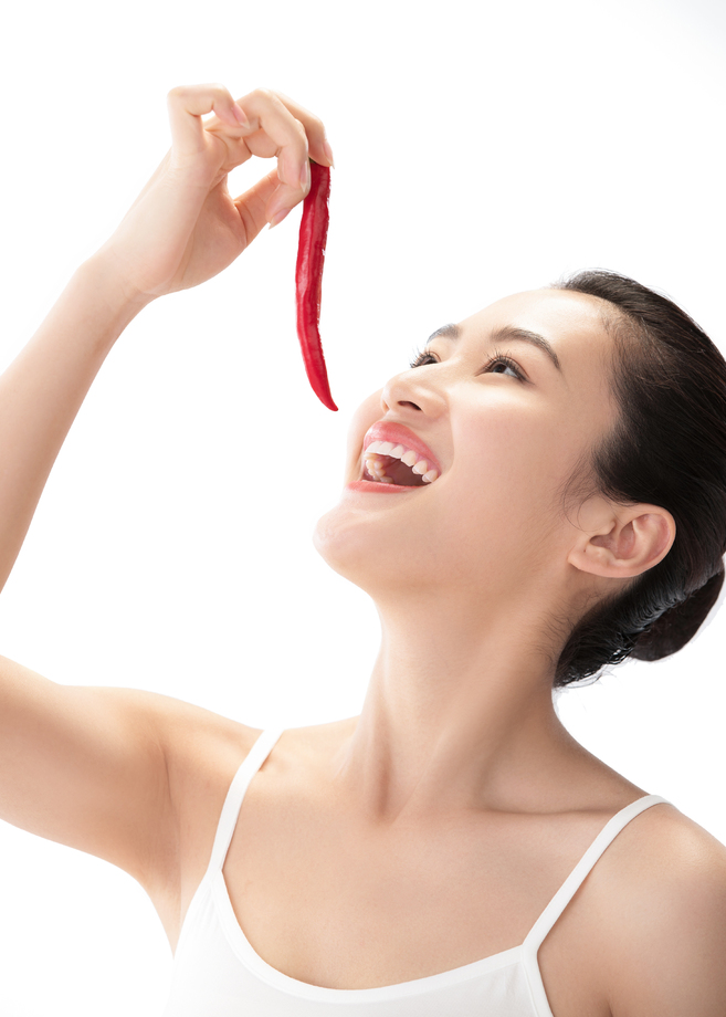 青年女人吃辣椒