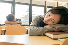 疲劳的大学生在教室里睡觉图片