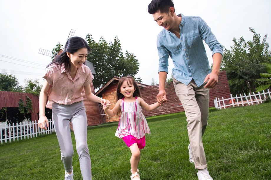 快乐三口之家在草地上奔跑