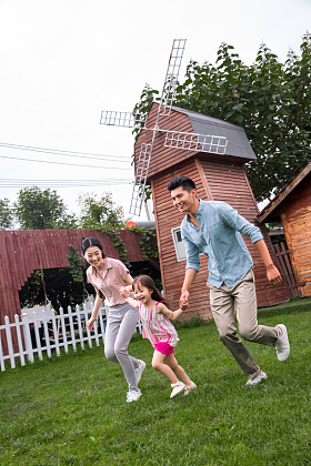 快乐三口之家在草地上奔跑