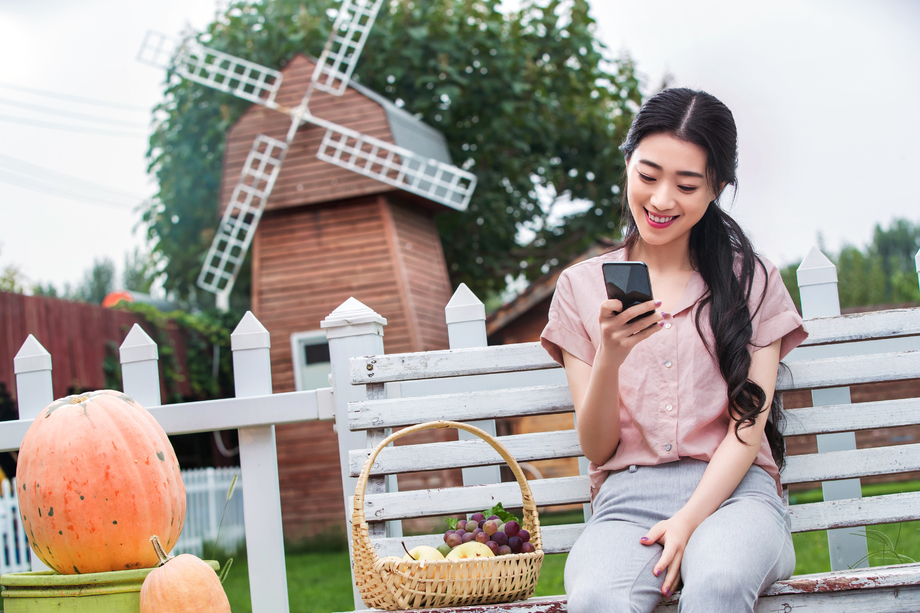 青年女人坐在户外看手机 青年女人坐在户外看手机