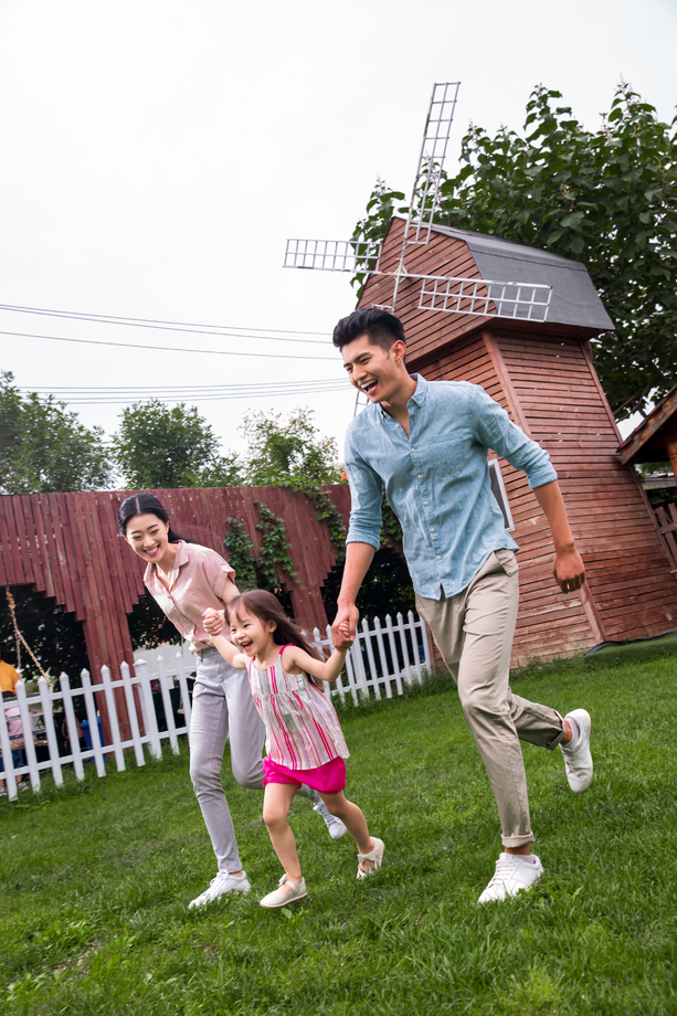 快乐三口之家在草地上奔跑