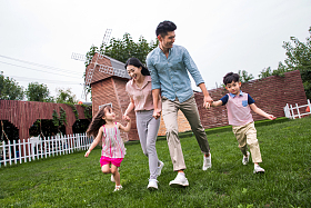 快乐四口之家在草地上奔跑